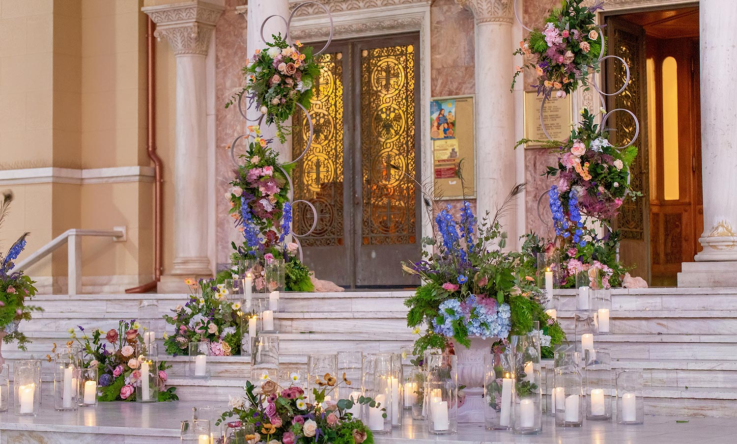 A Bridgerton Wedding in Greece 22 A Bridgerton style flower arrangements and candles decorating the stairs of Saint Andrew church for a Rogdaki Events Wedding.