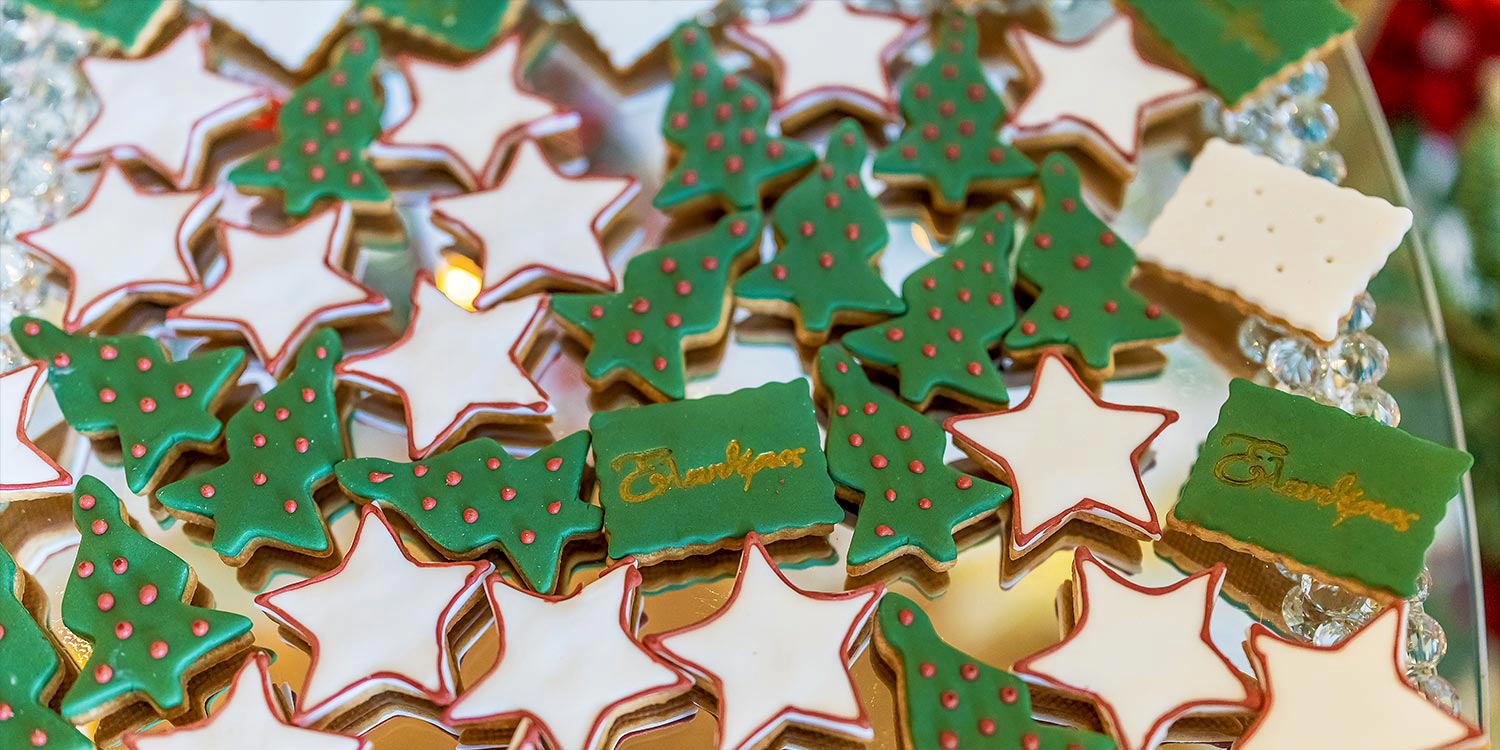Christmas cookies with star details and festive accents on an elegant dessert table by Rogdaki Events.