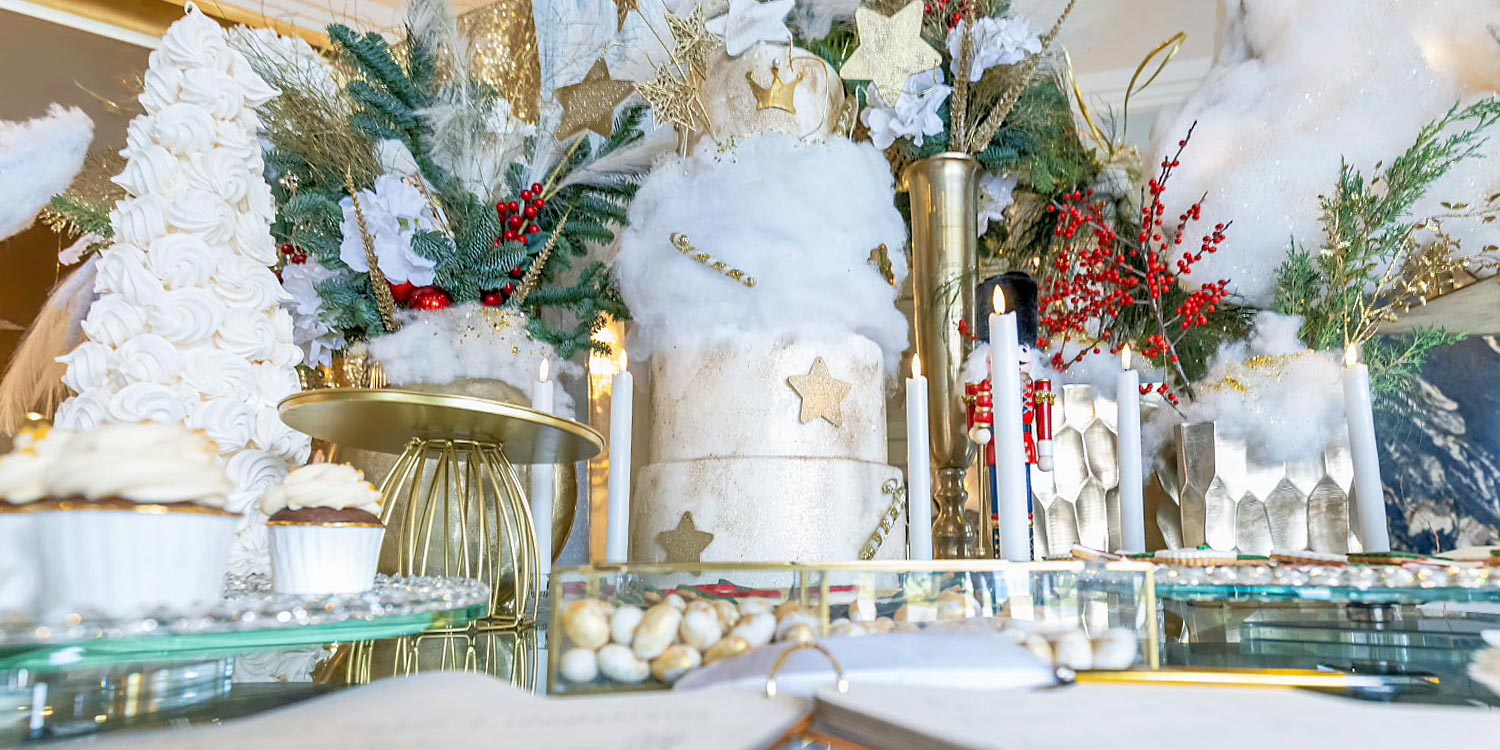 Christmas dessert table with a white cake, gold stars, and festive details by Rogdaki Events