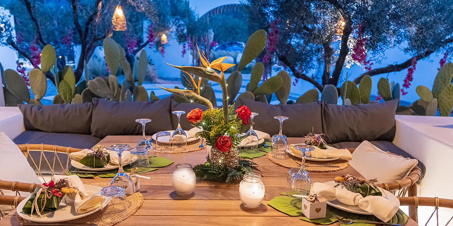Evening ONA table by Rogdaki Events featuring natural textures, soft lighting, and vibrant centerpiece accents