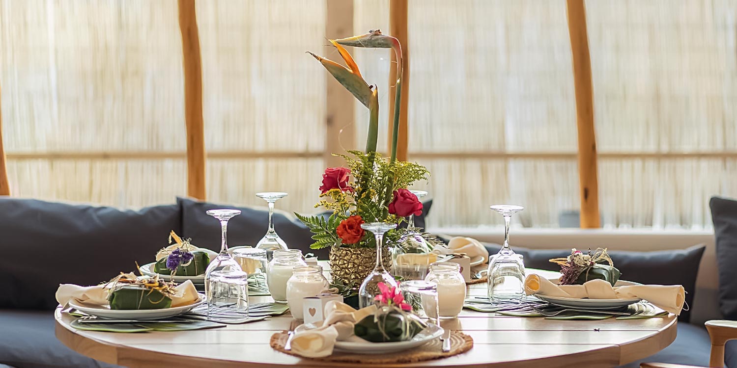 Table composition with exotic flowers and candles curated by Rogdaki Events for ONA