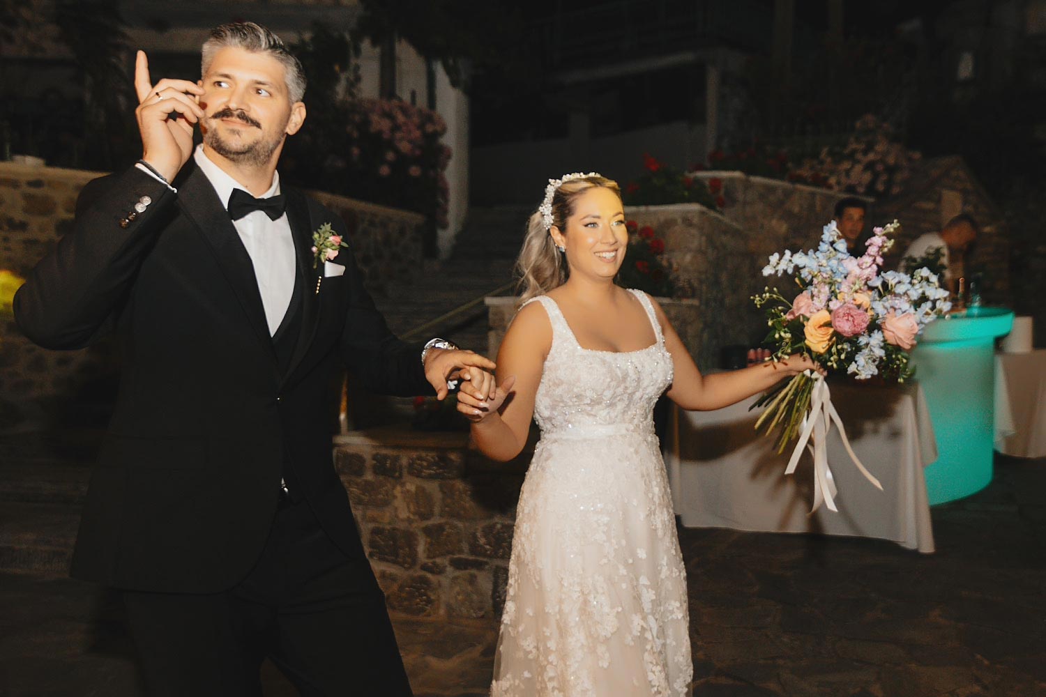 The newlyweds enter their reception hand in hand during this Rogdaki Events Authentic Village Square Wedding.