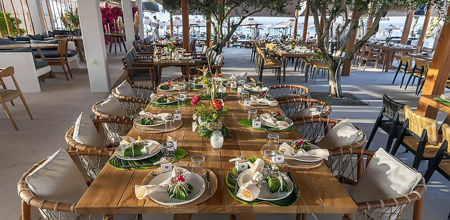 Vibrant table setup at ONA by Rogdaki Events with exotic flowers and yellow tones.