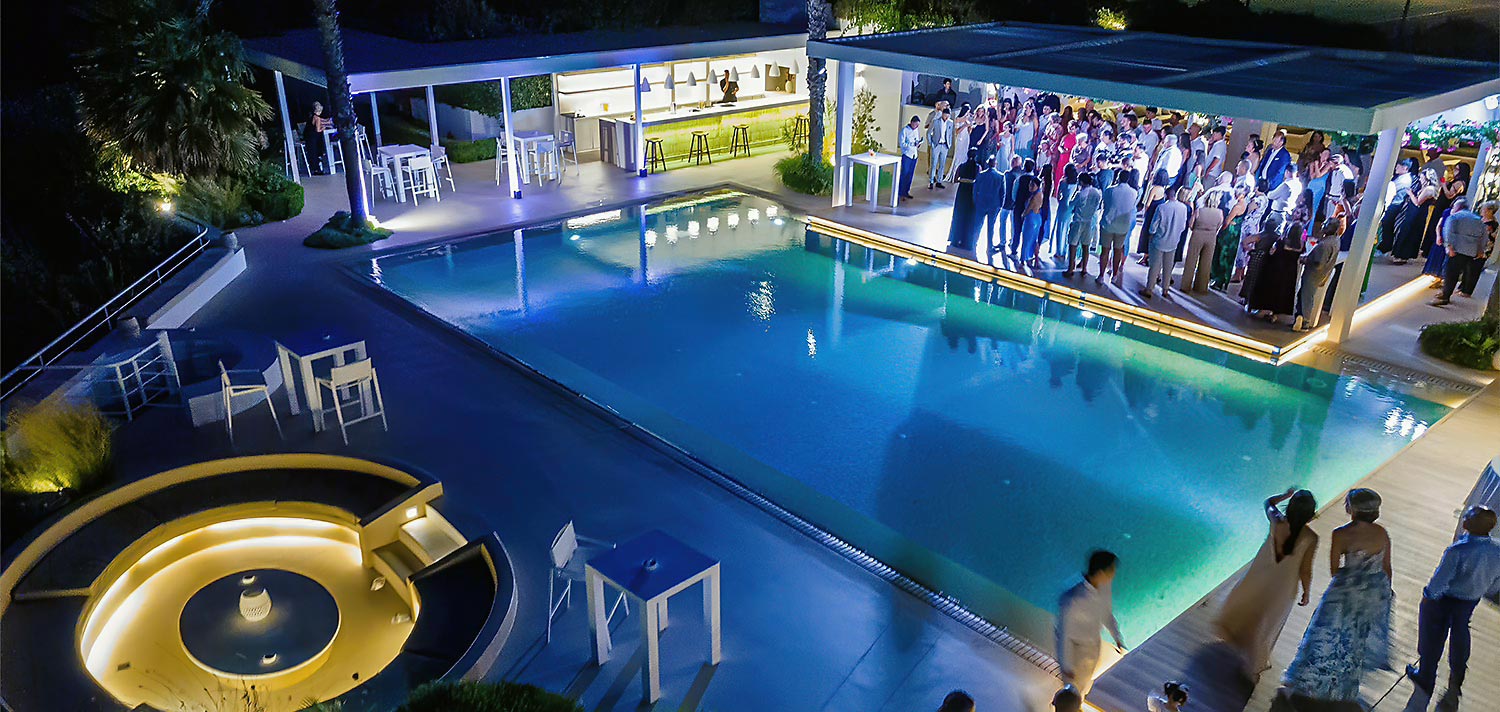 Minimal destination wedding στο Κτήμα 48 33 Μίνιμαλ στολισμός από τη Rogdaki Events στο Κτήμα 48 με καλεσμένους να διασκεδάζουν δίπλα στη φωτισμένη πισίνα