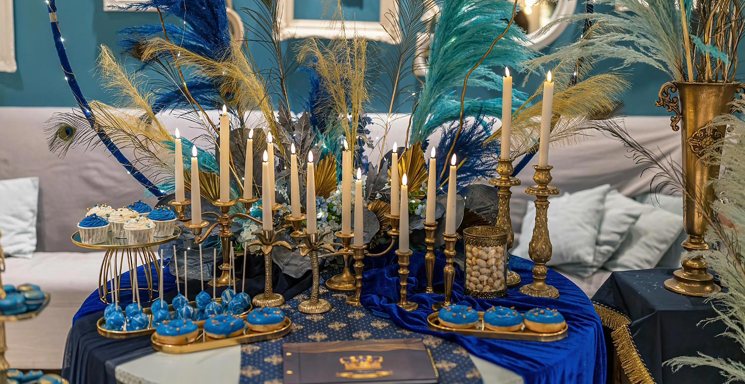 Βάπτιση Royal Baby | Elegant Στολισμός Μπλε & Χρυσό 25 Ατμοσφαιρικός στολισμός candy bar από τη Rogdaki Events με ψηλά λευκά κεριά, χρυσά κηροπήγια και χειροποίητα γλυκά σε royal blue αποχρώσεις
