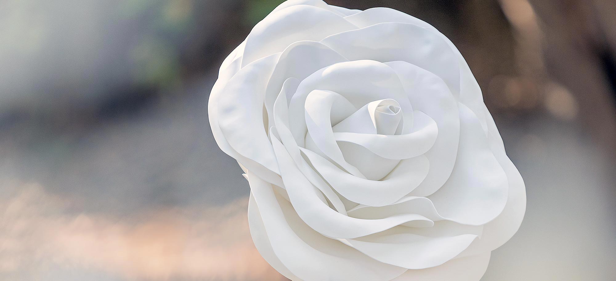 Close up of a handcrafted giant white rose for a forest baptism, a Rogdaki Events signature decor element