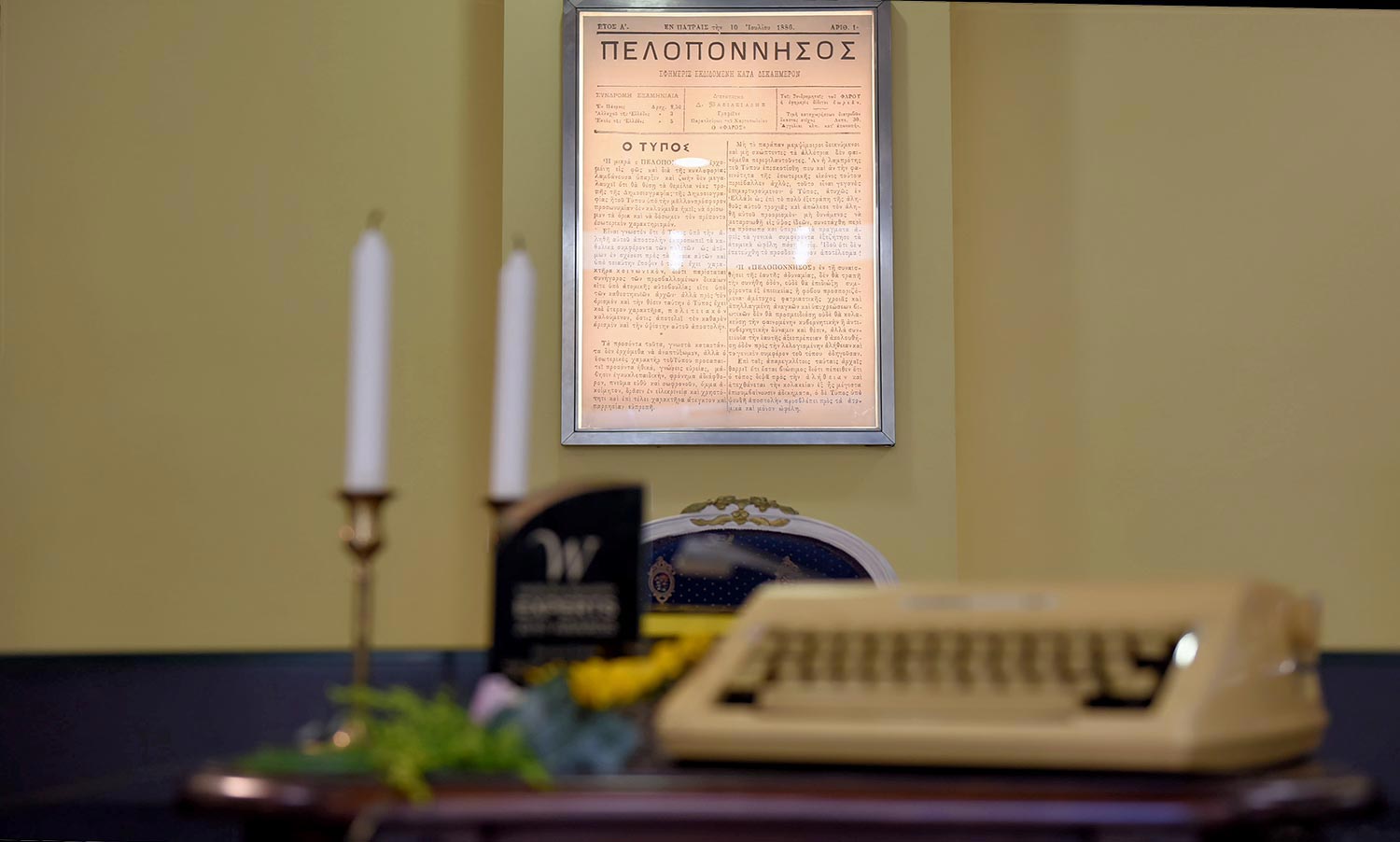 Στολισμός Εταιρικής Εκδήλωσης για τα 130 Χρόνια της Εφημερίδας «Πελοπόννησος» 9 Εστίαση στο ιστορικό, κορνιζαρισμένο πρωτοσέλιδο της εφημερίδας Πελοπόννησος, πλαισιωμένο από vintage στοιχεία της Rogdaki Events