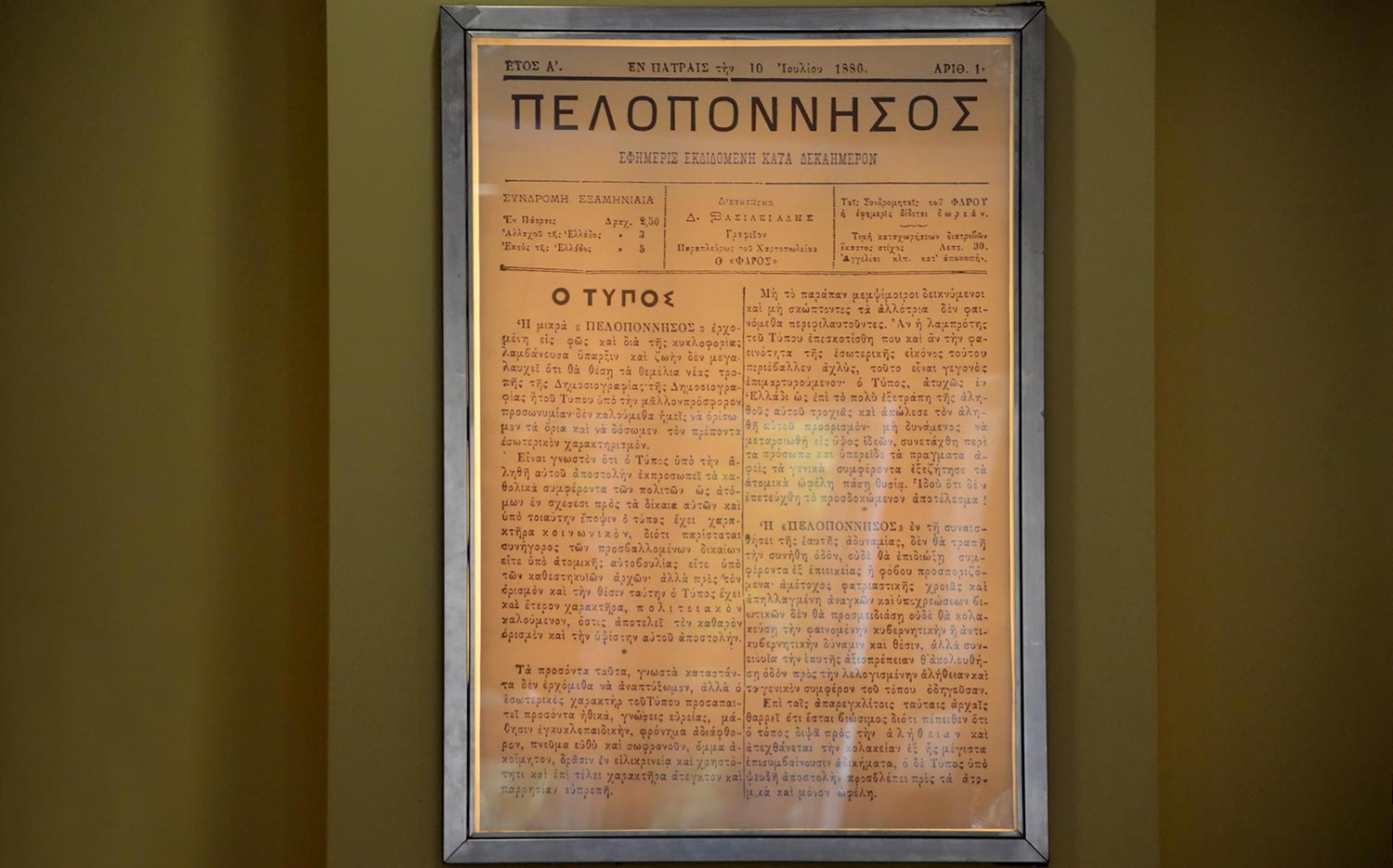 Στολισμός Εταιρικής Εκδήλωσης για τα 130 Χρόνια της Εφημερίδας «Πελοπόννησος» 10 Κοντινή λήψη του πρώτου φύλλου της εφημερίδας Πελοπόννησος από τις 10 Ιουλίου 1886, μέρος του ιστορικού ντεκόρ της Rogdaki Events Trademark