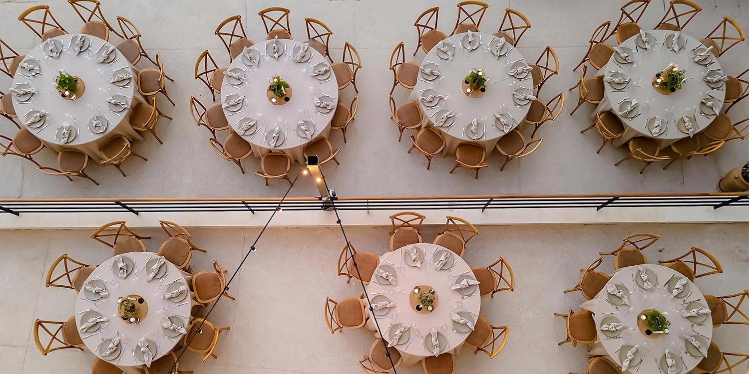 Aerial view of symmetrical table arrangement for a corporate event by Rogdaki Events Design.