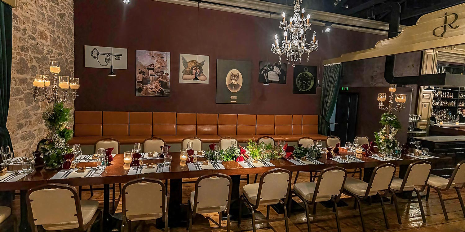 Ονομαστήρια Σεβασμιωτάτου Μητροπολίτου Πατρών 5 Μακρόστενο τραπέζι με ψηλά κηροπήγια για τα γενέθλια του Μητροπολίτη Πατρών, πλαισιωμένο από ιδιαίτερα έργα τέχνης στον χώρο