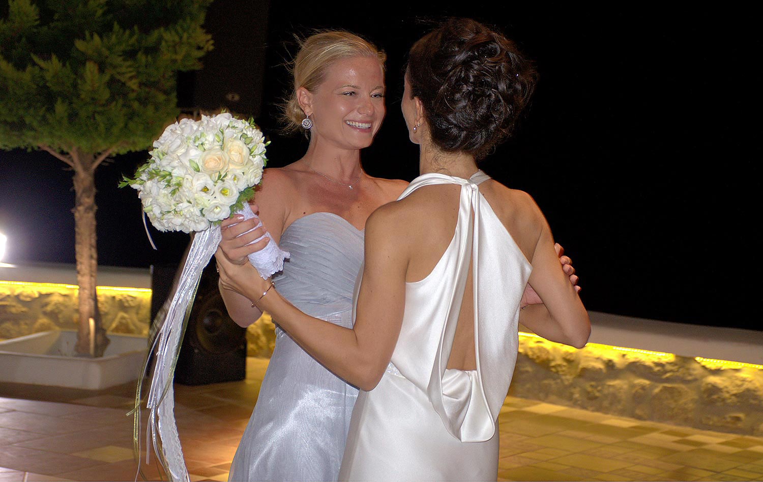 Mykonos | Japanese-Romanian Destination Wedding 36 The bride and bridesmaid sharing a dance at a Japanese Romanian wedding in Mykonos' Saint John, by Rogdaki Events