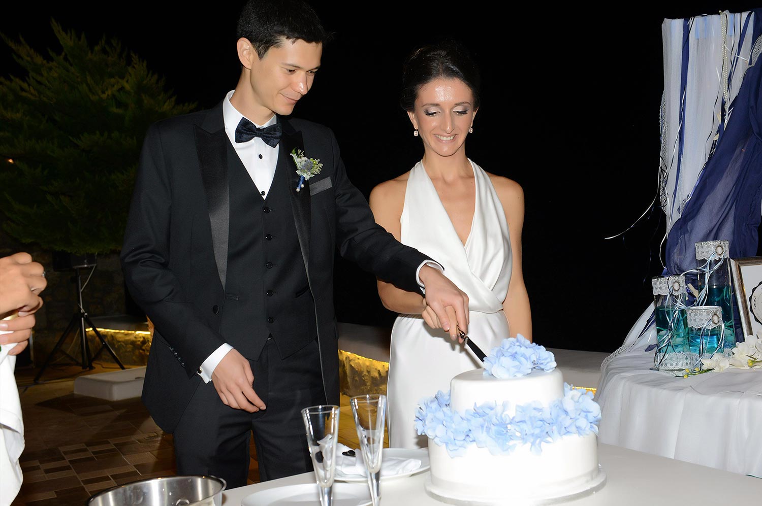 Mykonos | Japanese-Romanian Destination Wedding 37 The married couple cutting their wedding cake at a Japanese Romanian wedding in Mykonos' Saint John, by Rogdaki Events
